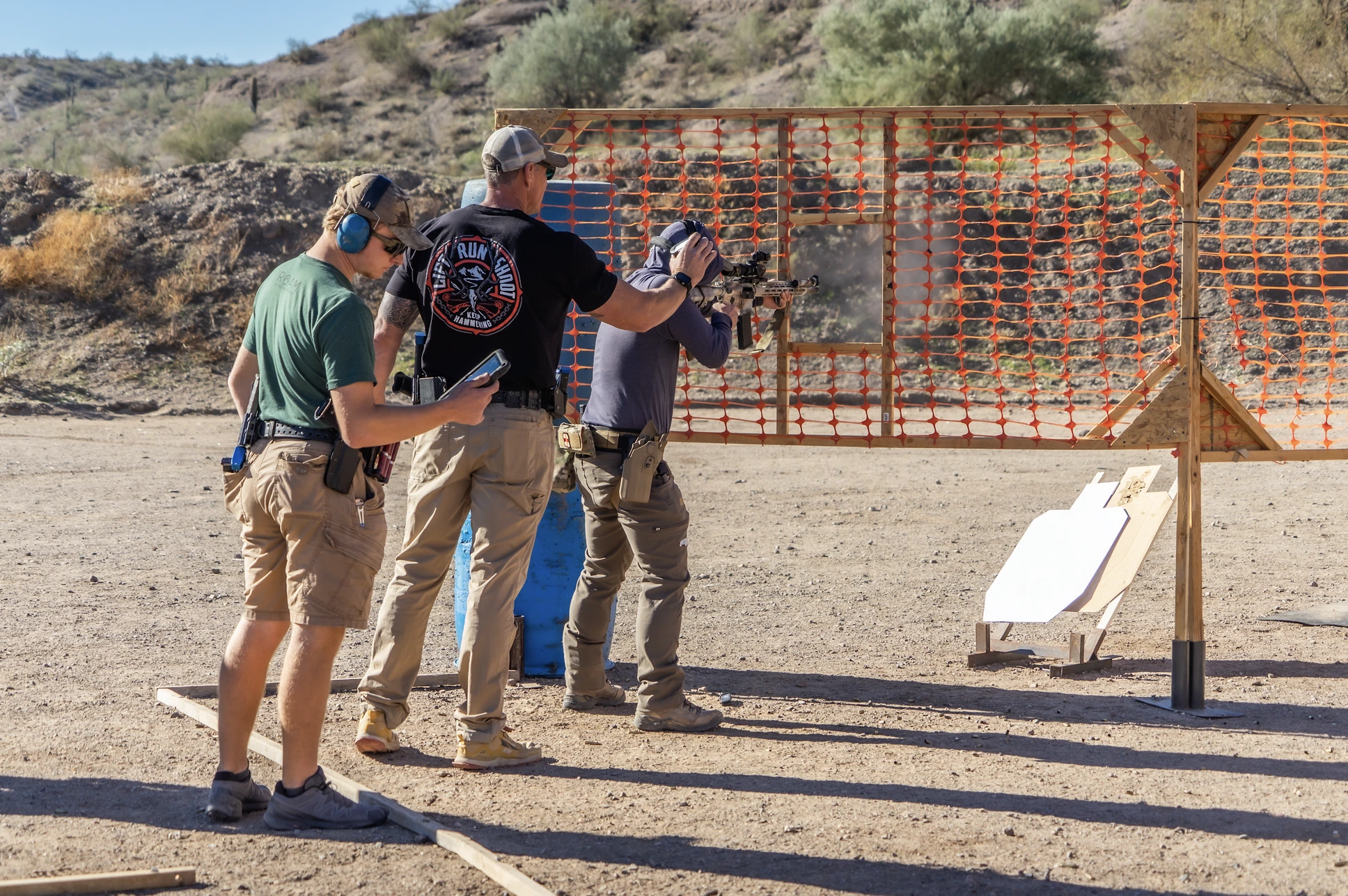 An ex-Special Ops instructor providing direct, technical guidance to a shooter on a dynamic range. This visual represents the "Rugged Mentor" archetype, offering authoritative but accessible expertise.