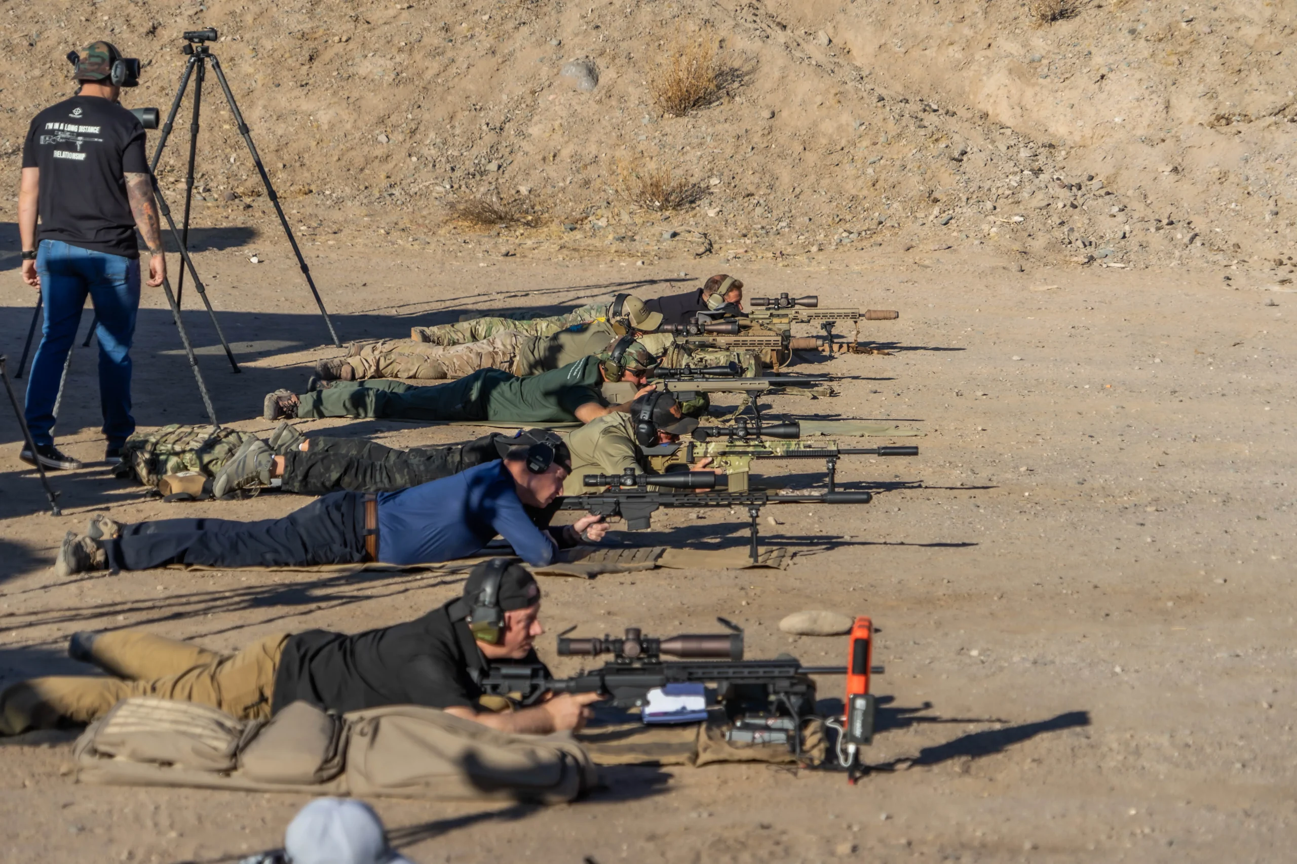 Precision rifle shooters train in the prone position with scoped systems on a 1,000-yard desert platform.