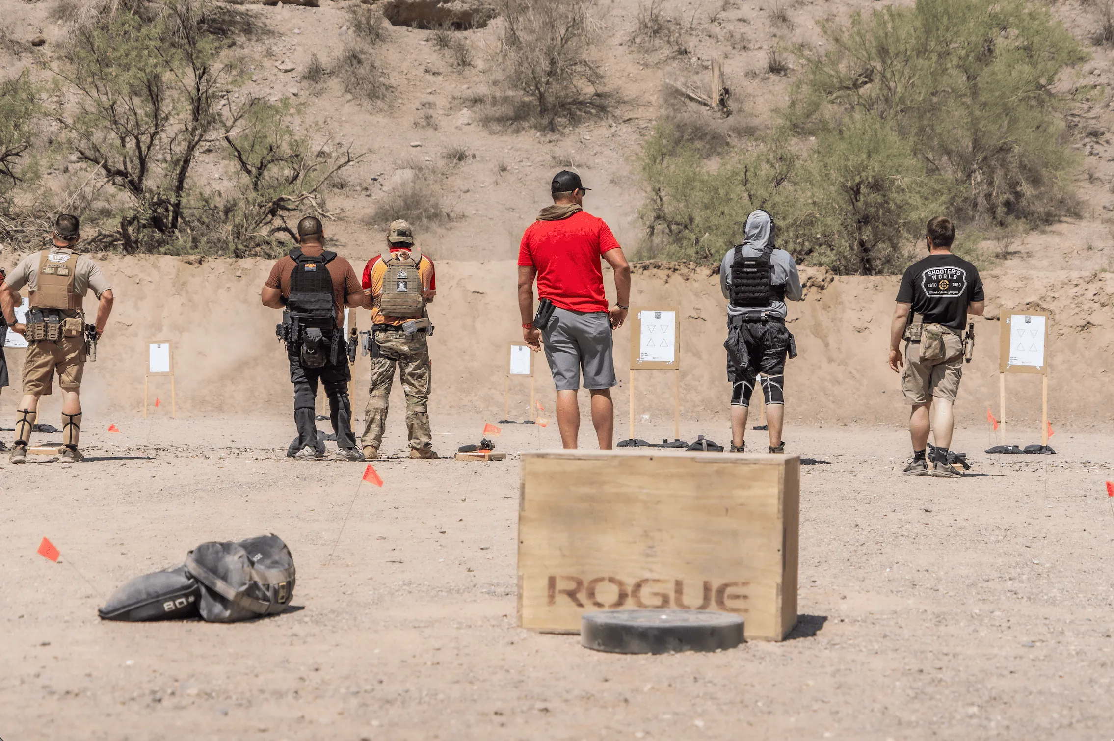 Tactical shooters and an instructor stand on an open-air firing line during a dynamic carbine handling course at Cowtown Range's high-desert facility in Peoria, Arizona.