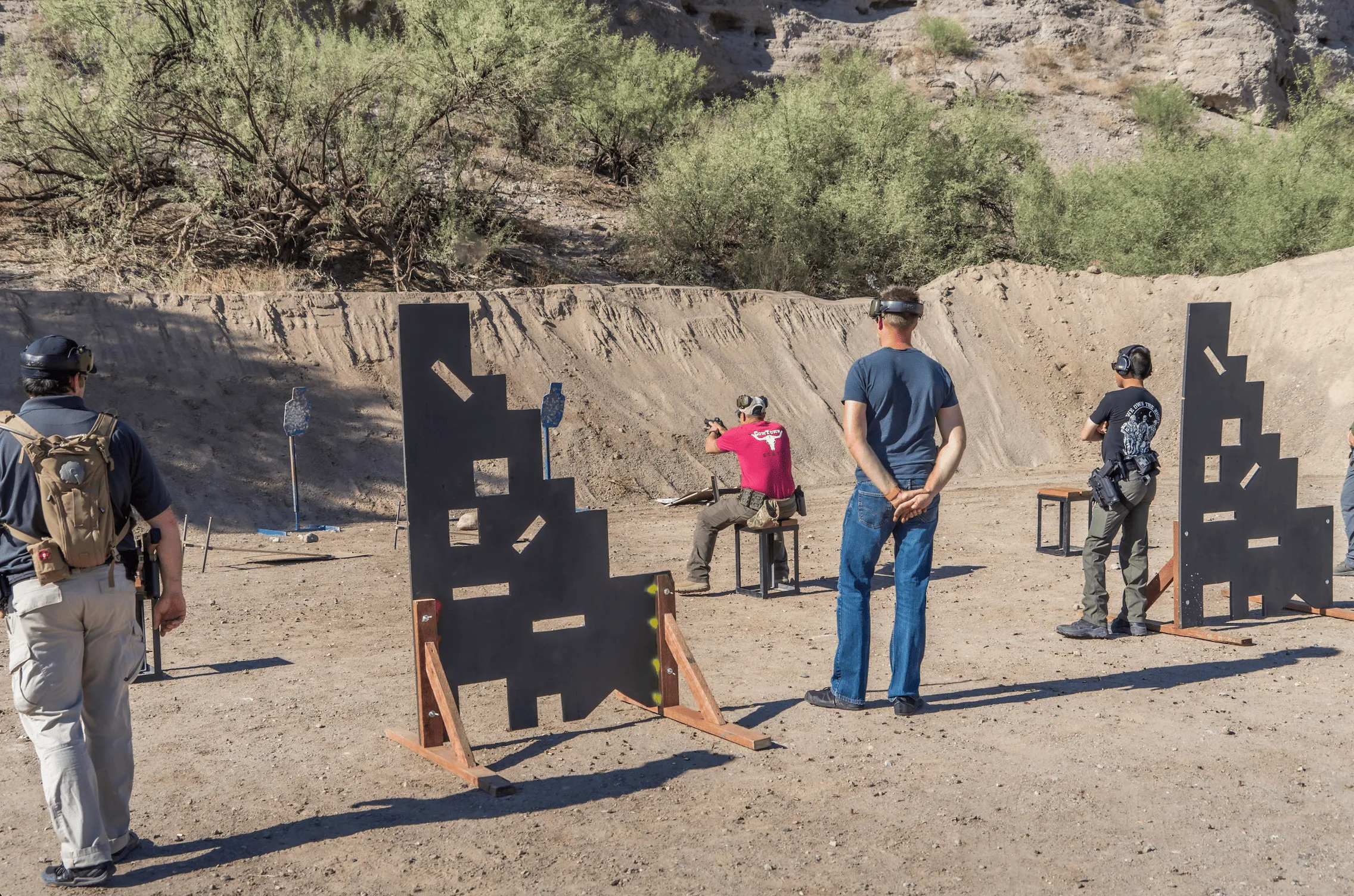 Shooters practicing movement and barricade drills on a dynamic outdoor tactical bay at Cowtown Range.