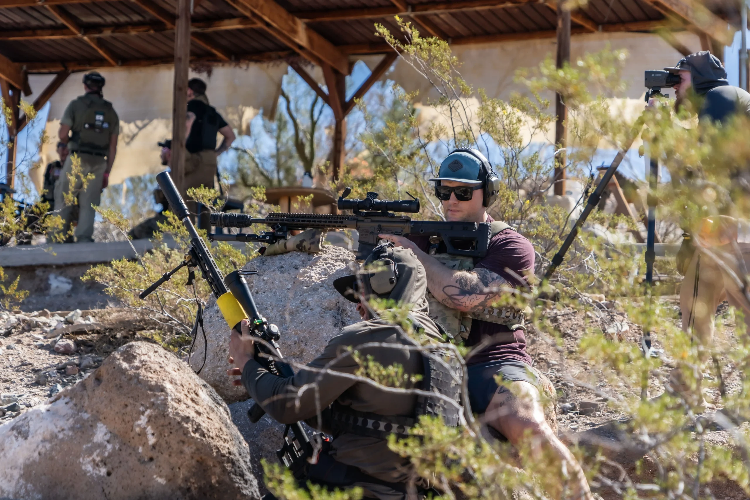 Shooters use a high-desert rock barricade for precision rifle training on a long-range platform at Cowtown Range.