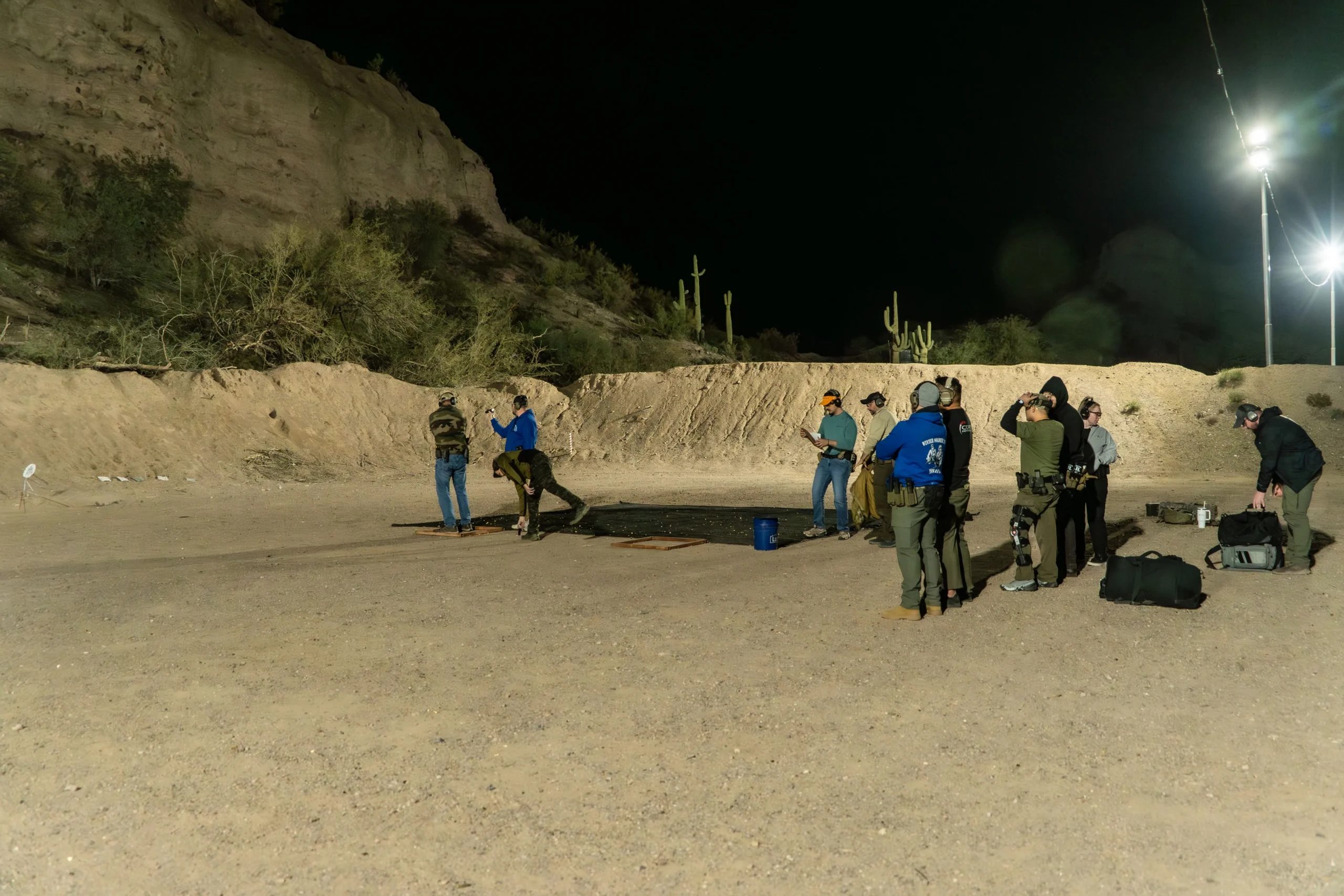 A line of shooters practices low-light platform engagement during a night shooting session at Cowtown Range.