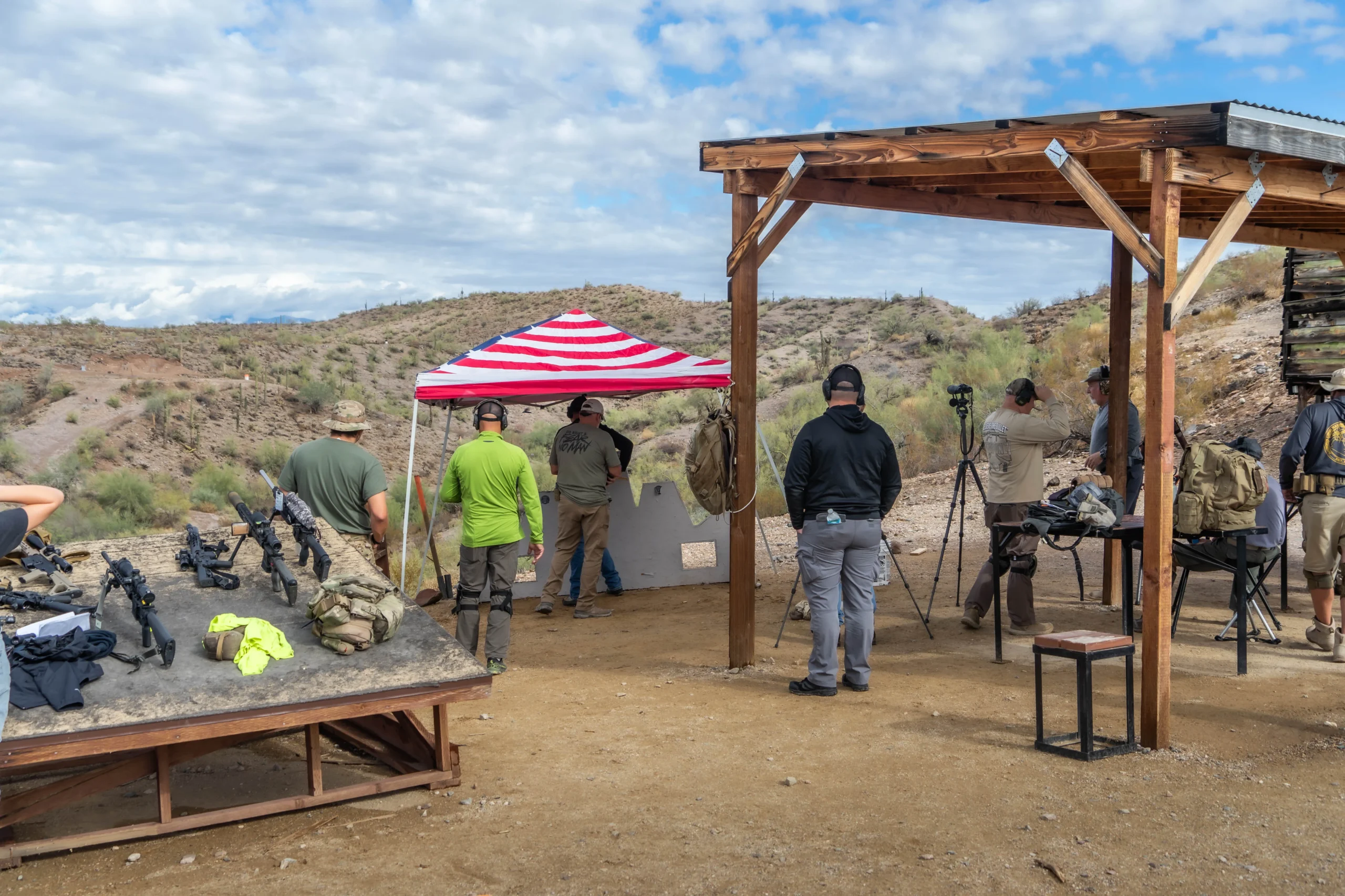 Shooters running rifle systems from a covered shooting platform at Cowtown Range's high-desert facility.