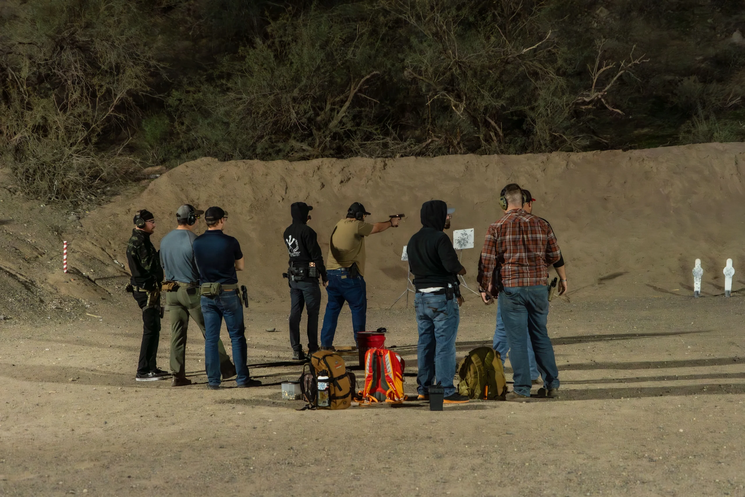 Shooters conduct low-light platform training under overhead bay lights at Cowtown Range in Peoria, AZ.