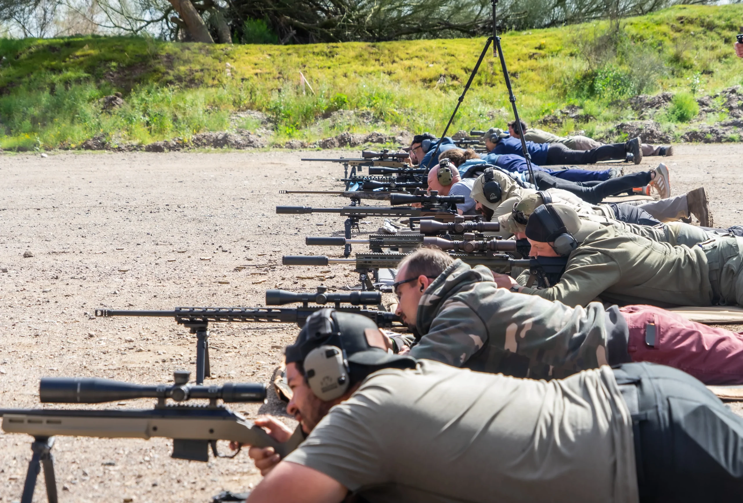 Shooters lying prone on the long-range precision line running scoped platforms downrange.