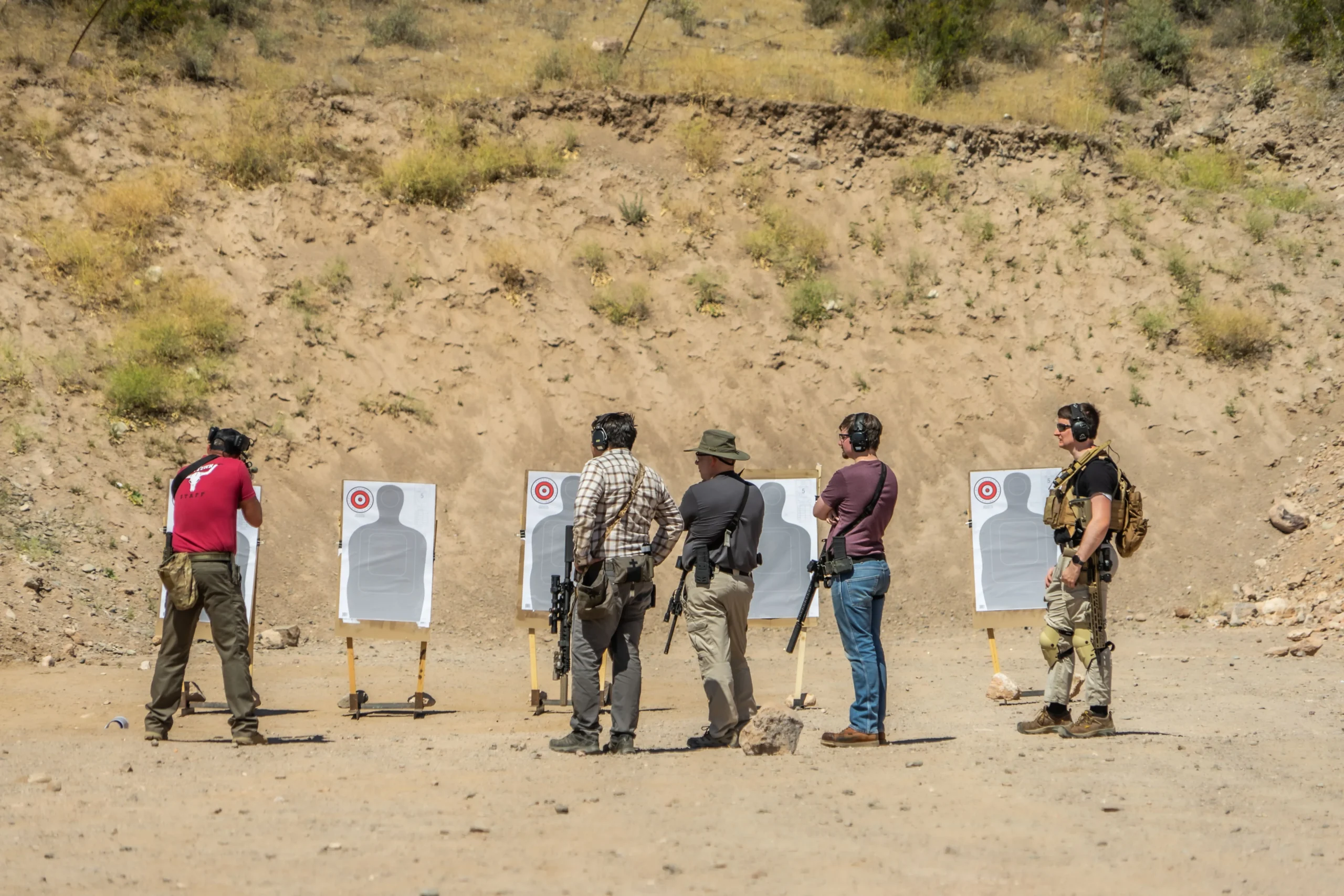 Shooters lined up on paper silhouettes with carbine platforms during a dynamic movement class.